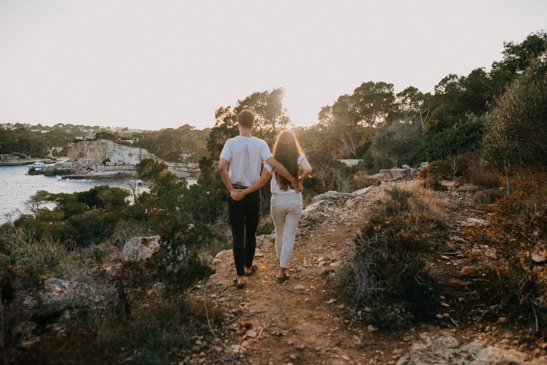 Couple Walking at the Rock Path of the Beach